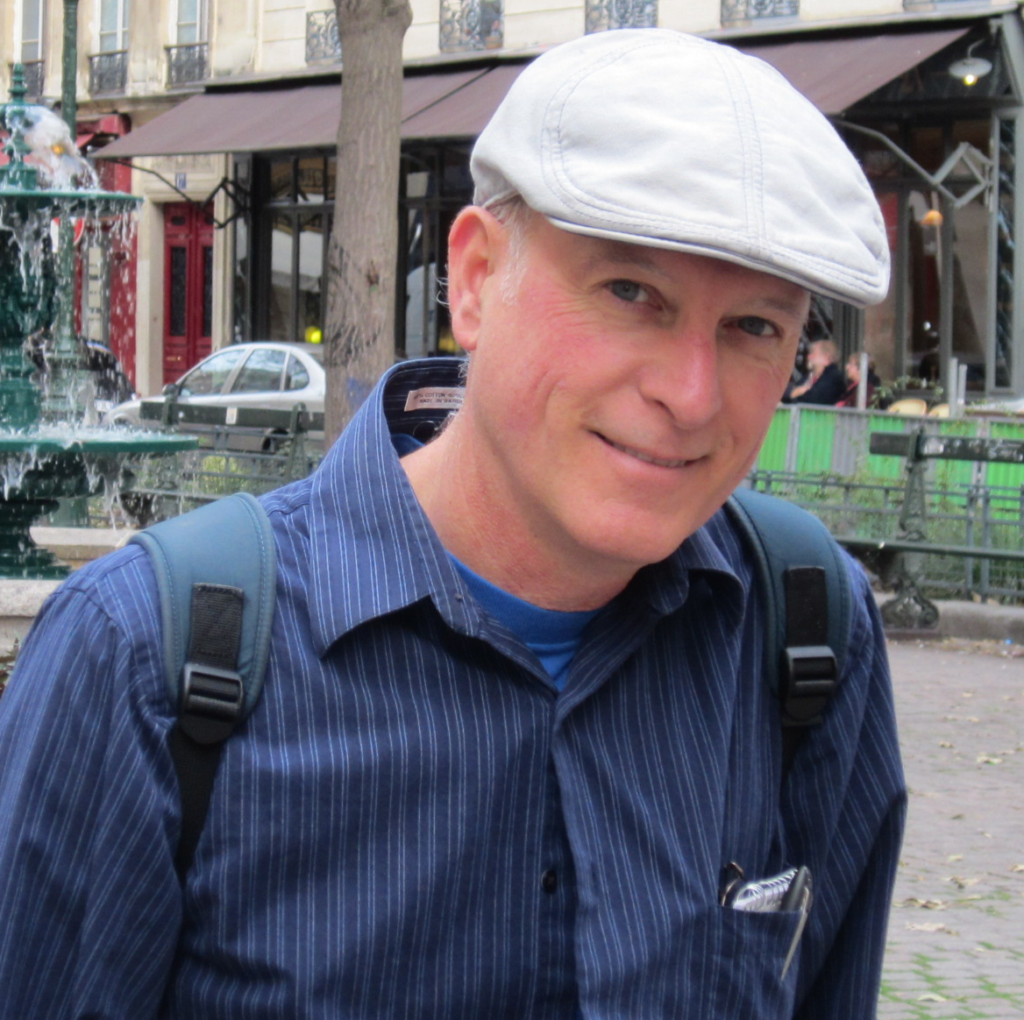 Photo of John Boykin in front of a cafe in Paris