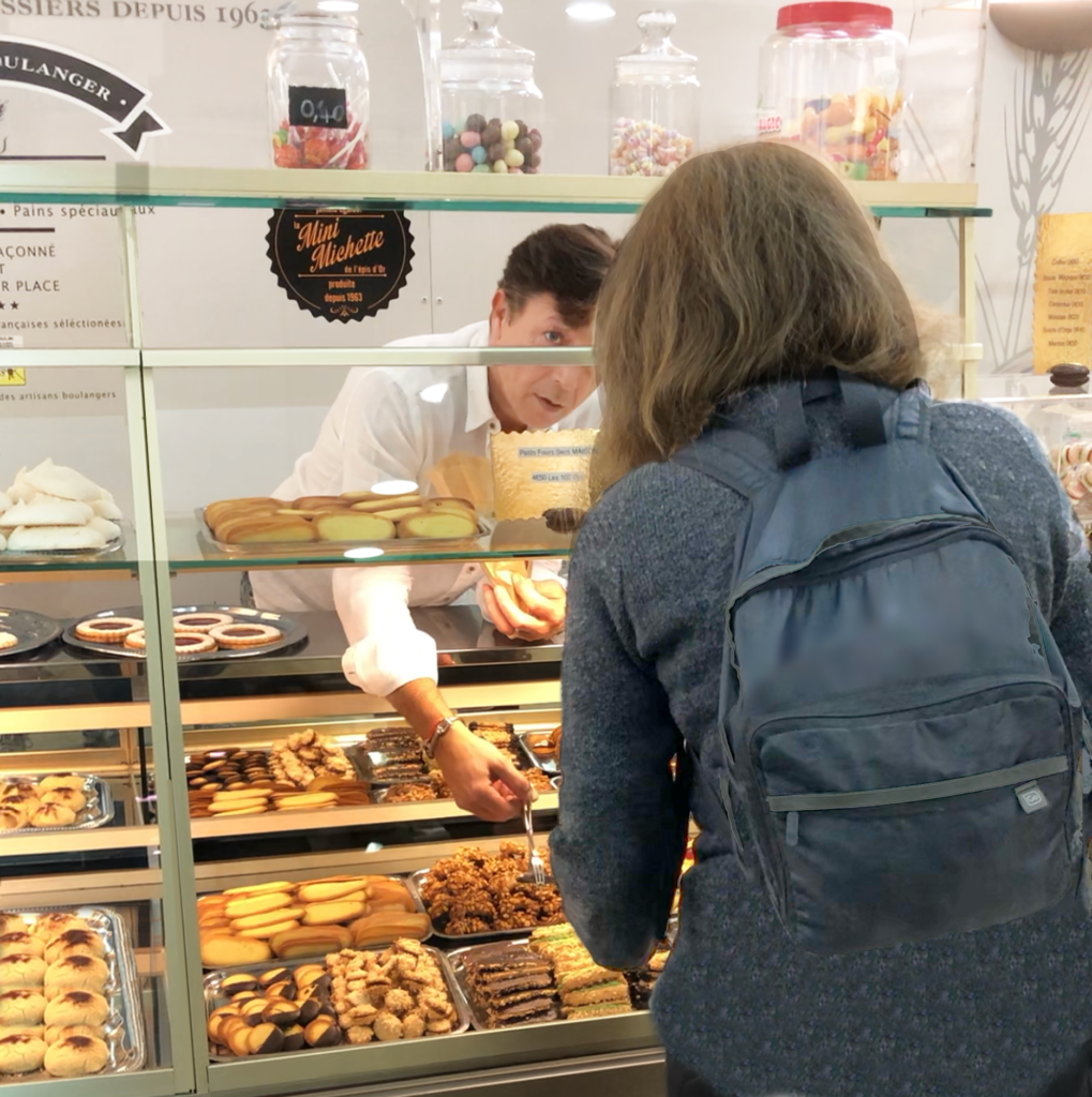 Baker helping a female traveler pick out a pastry